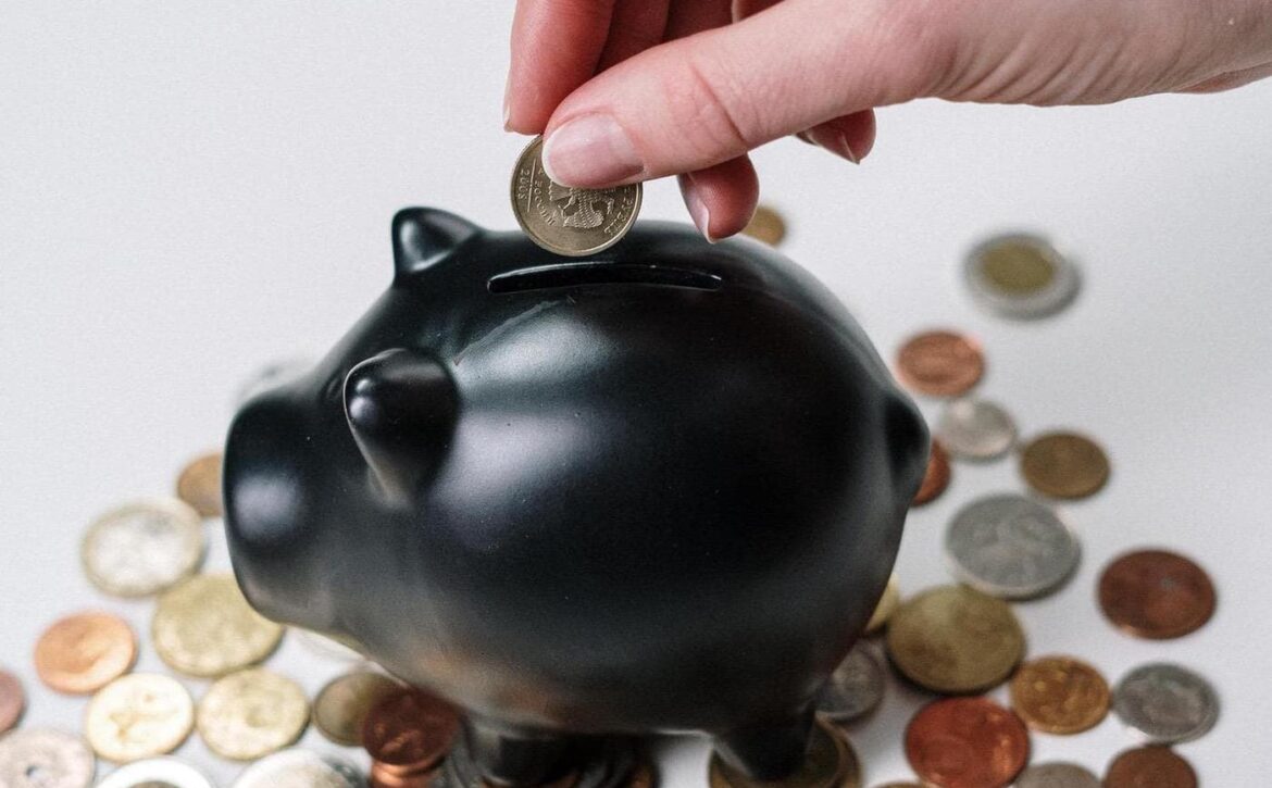 person-holding-black-ceramic-pig-coin-bank-3943723