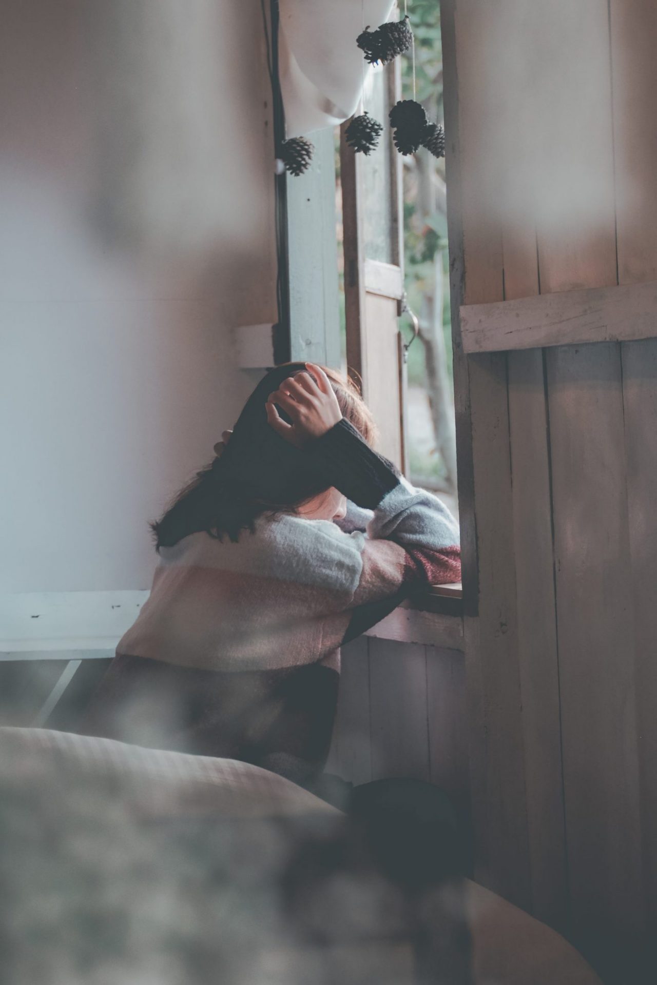 photo-of-a-person-leaning-on-wooden-window-1510149-scaled