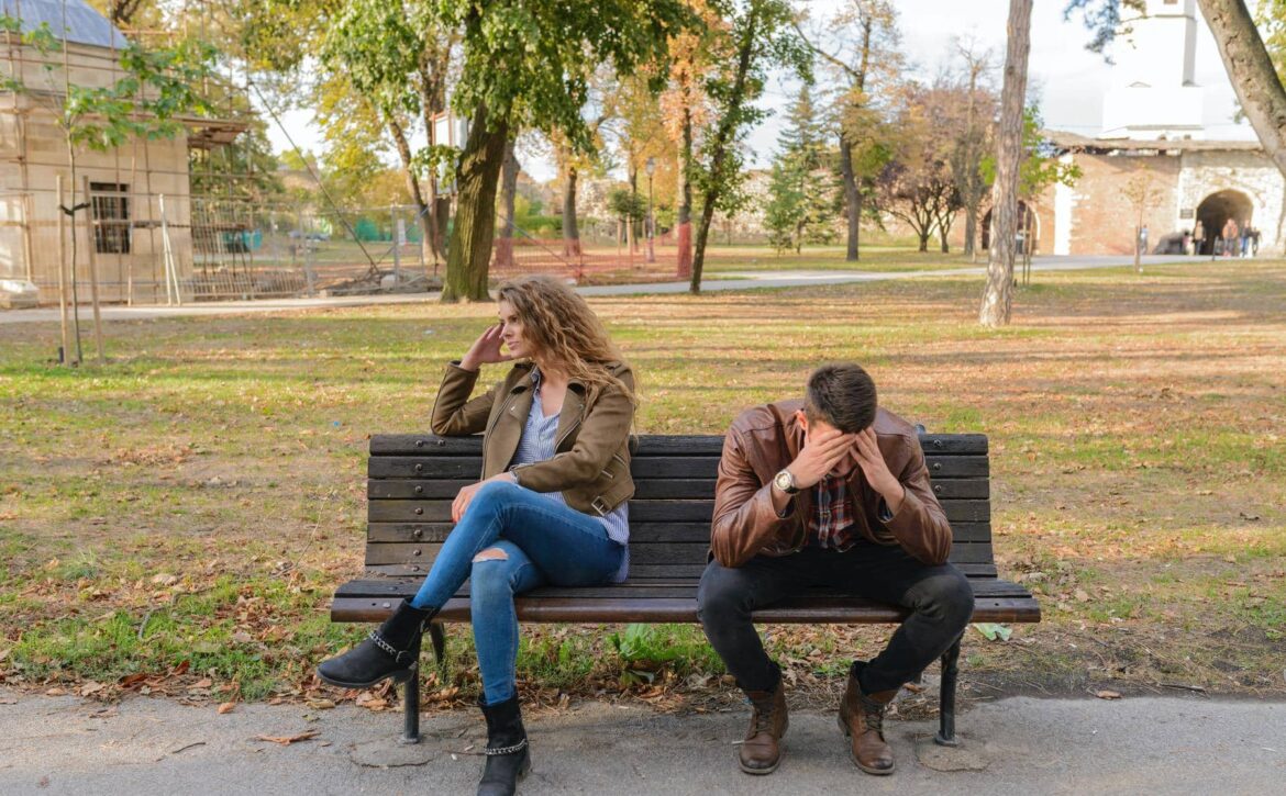 woman-and-man-sitting-on-brown-wooden-bench-984949