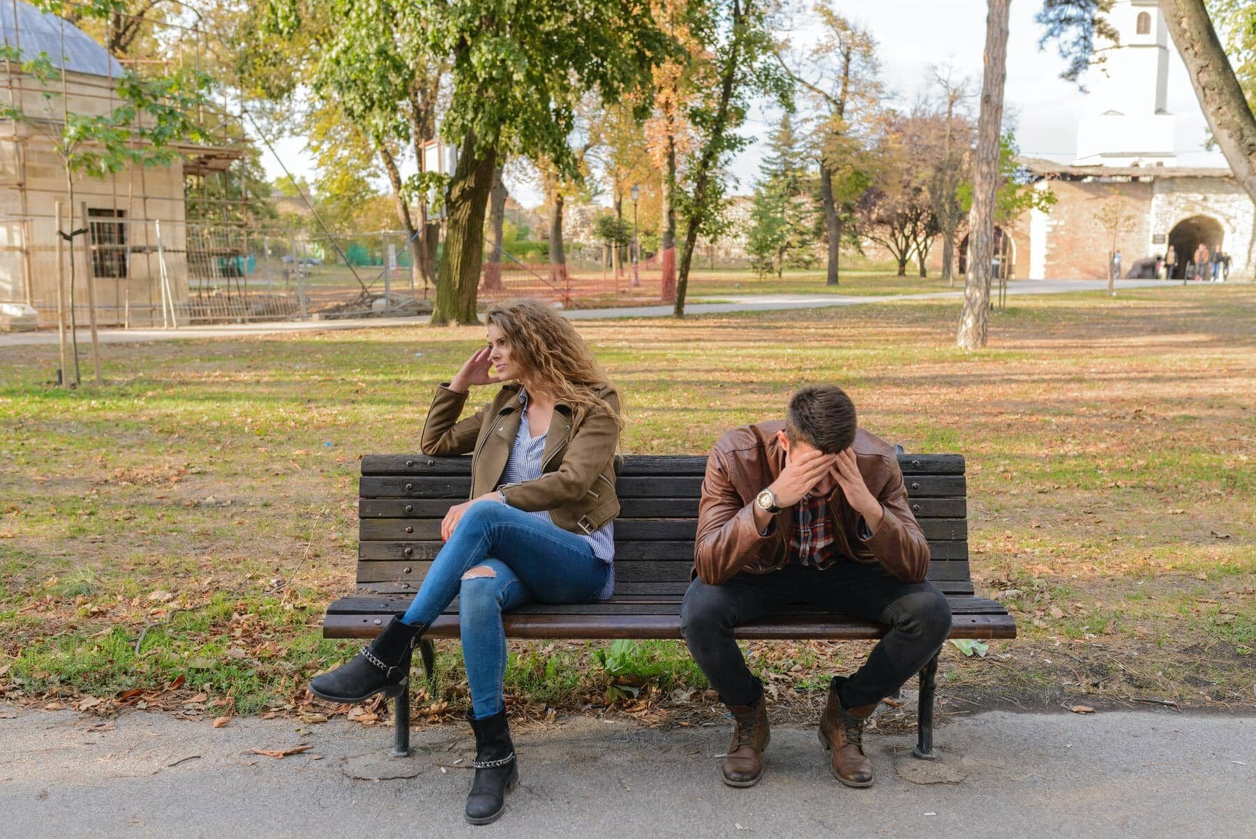 woman-and-man-sitting-on-brown-wooden-bench-984949